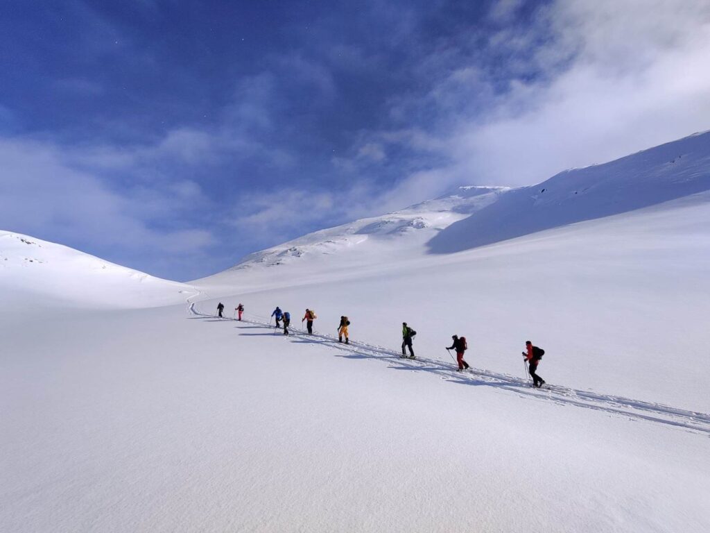 Gruppe på topptur i urørt snø.